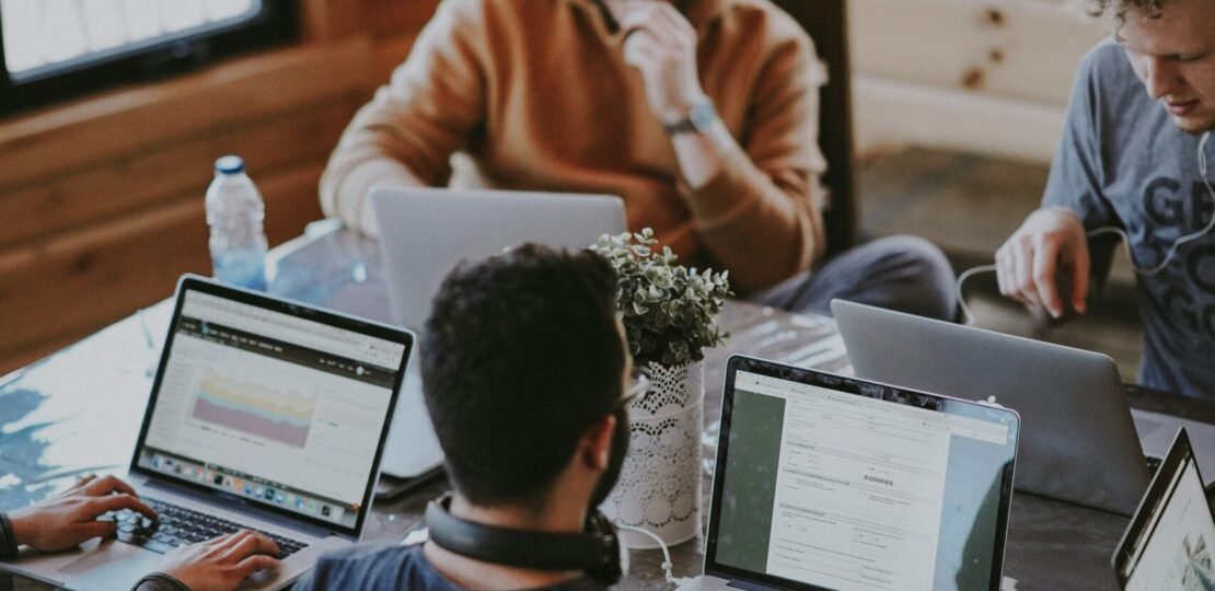 men sitting in front of their laptop computer